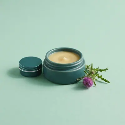 Thistle & Arnica Body Balm on a mint green background